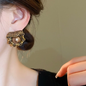 Gros plan de boucles d'oreilles vintage avec cristaux bruns et perles sur un mannequin