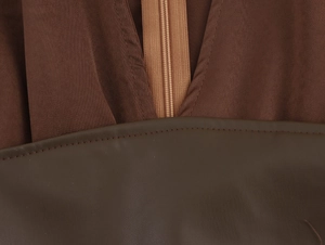 Detail of coffee brown chiffon fabric with zipper and faux leather stitching on dress