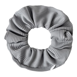 Detail view of gray tie-dye velvet hair scrunchie with soft ribbed texture on white background