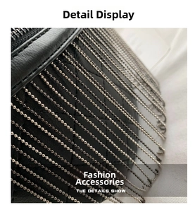 Close-up of black quilted leather texture with silver metal beaded chain fringe detail