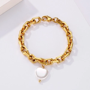 Detaillierte Makroansicht des goldenen Gliederkettenarmbands mit weißem Herzanhänger