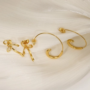 Exquisite 18K gold plated stainless steel bow earrings and C-shaped hoops on white silk