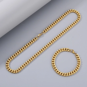 Ensemble collier et bracelet maille gourmette dorée sur présentoir minimaliste