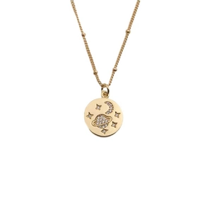Detail shot of a gold necklace featuring a zircon encrusted moon and star pendant