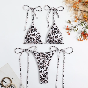 Flat lay of floral bikini set with halter top and side-tie bottom on white background