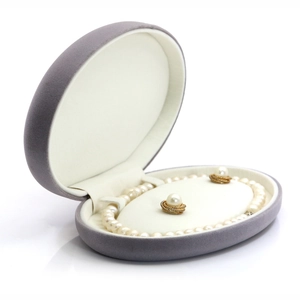 Gray velvet jewelry box featuring a pearl necklace and earrings set in a diagonal view