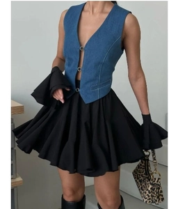 Détail de la jupe plissée à taille haute avec gilet en jean et boucle en métal