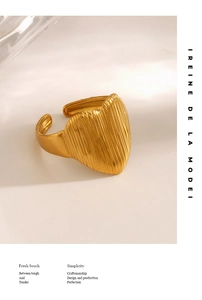 Detail of a gold heart ring featuring vertical striped texture and adjustable band