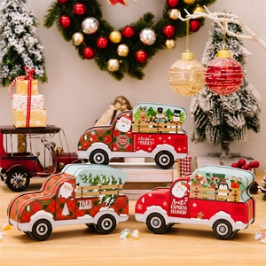 Detailed view of three festive truck-shaped Christmas tin candy boxes for gifts