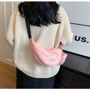 Borsa a tracolla rosa in nylon a mezzaluna con portamonete coordinato su maglione beige