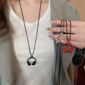 Close-up of headphone pendant necklaces in black, silver, and red on woven chains