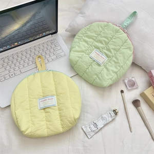 Quilted shell-shaped cosmetic bags in soft yellow and mint green for travel storage