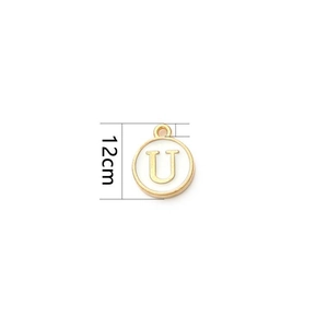 Detail of a 12mm round white enamel charm with a gold letter U for DIY jewelry making