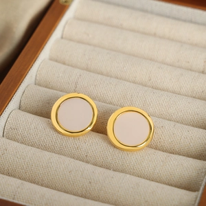 Elegant geometric gold and white round stud earrings displayed in a luxury jewelry box