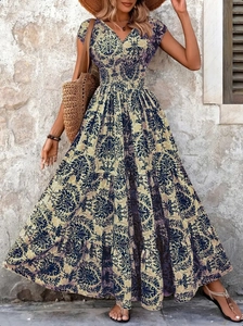 Detail of bohemian floral maxi dress with V-neck and tiered skirt on stone wall background