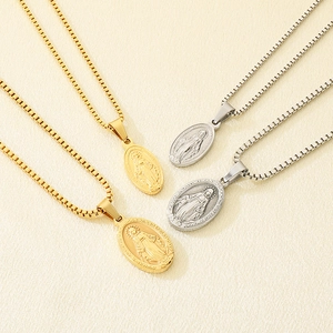 Close-up of 18K gold and silver oval Virgin Mary pendant necklaces with box chain