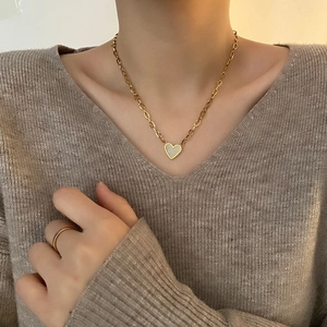 Elegant gold heart pendant necklace with white shell inlay and matching minimalist ring