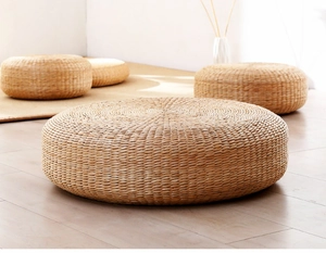 Dettaglio di un pouf in paglia intrecciato a mano con texture naturale e stile zen