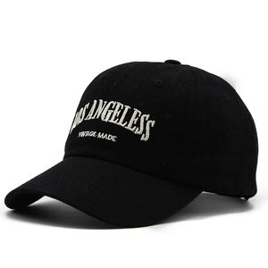 Close-up of white Los Angeles embroidery on black washed cotton baseball cap texture