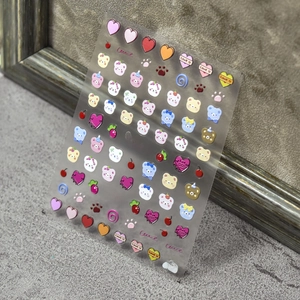 Macro detail of 3D embossed nail stickers featuring colorful cartoon bears and hearts