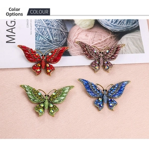 Détail de quatre broches papillon en strass aux couleurs rouge, violet, vert et bleu ciel