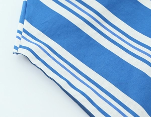 Macro view of blue and white striped linen fabric showing precise side stitching details