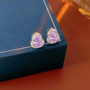 Macro shot of silver stud earring featuring a purple gourd gemstone with zircon halo