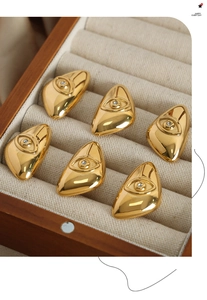 Macro shot of six gold eye-shaped rings with white zircons in a velvet jewelry box