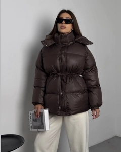 Detail of dark brown quilted cotton jacket featuring drawstring waist and stand collar