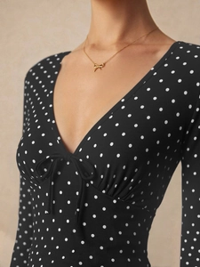 Abito corto nero a pois bianchi con scollo a V e dettaglio fiocco sul davanti