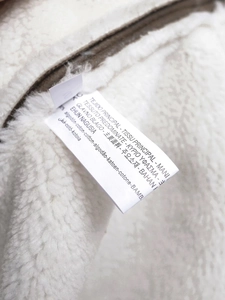 Detail view of the inner garment label showing cotton fabric composition on white fleece