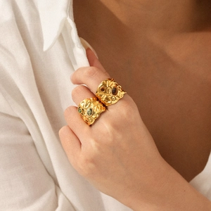 Detail of gold hammered stainless steel rings with tiger eye stones on model hand