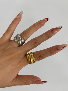 Detailed close-up of gold and silver twisted croissant rings on a female hand