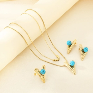 Close-up of gold layered necklace set featuring turquoise beads and V-shaped pendants