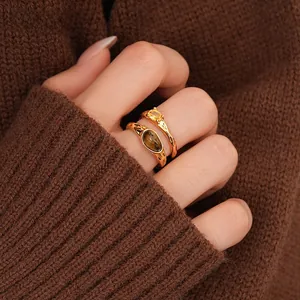 Close-up of dual-layer rings with tiger eye stone and crystals on vintage gold bands