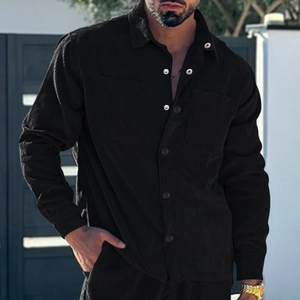 Detail of black corduroy men's shirt showing the contrast buttons and collar texture