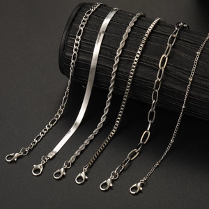 Detail view of silver chains showing Figaro, snake, and twisted textures with lobster clasps