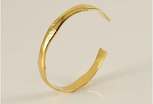 Close-up of 18K gold plated stainless steel C-shaped cuff with bamboo texture