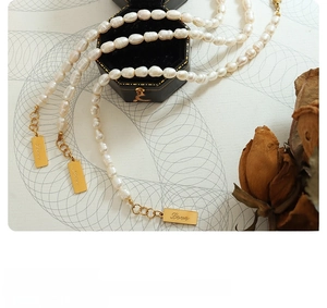 Detail of 18K gold-plated letter pendant on freshwater pearl bracelet with Love engraving