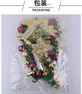 Detailed view of a Christmas teardrop wreath with gold bows and ornaments in packaging