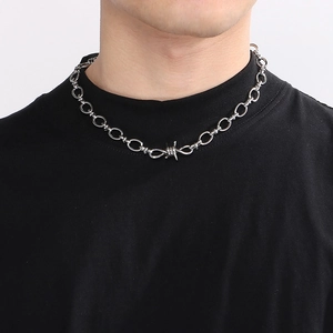 Close-up of unisex silver stainless steel barbed wire necklace worn on model neck