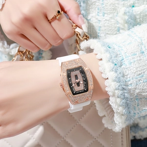 Close-up of diamond-encrusted tonneau watch with rose gold case and white silicone strap