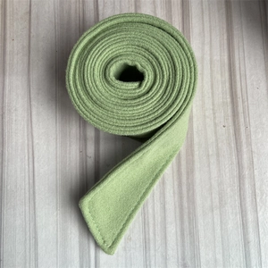 Detailed close-up of light green wool coat belt showing soft brushed texture and thickness