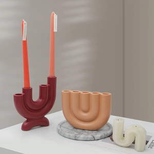 Modern minimalist geometric candle holders with U-shape and wavy designs in artistic setting