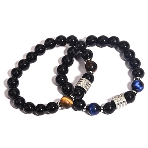 Detailed macro view of black obsidian and blue tiger eye beads with silver accent spacers