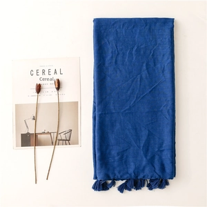 Detail of dark blue cotton linen scarf with subtle gold shimmer and tassel fringe edges