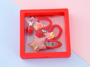 Detail view of red Christmas hair accessory set in gift box with stars and polka dots