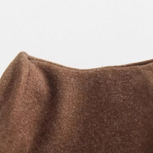 Close-up of brown wool fabric texture on a women's loose long-sleeved stand collar jacket
