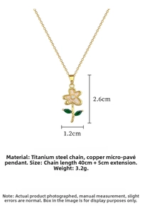 Detail of flower pendant with white shell petals and green gems on a gold steel chain