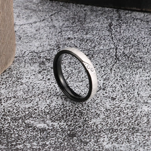 Detail of brushed silver and polished black steel ring with three inset diamonds